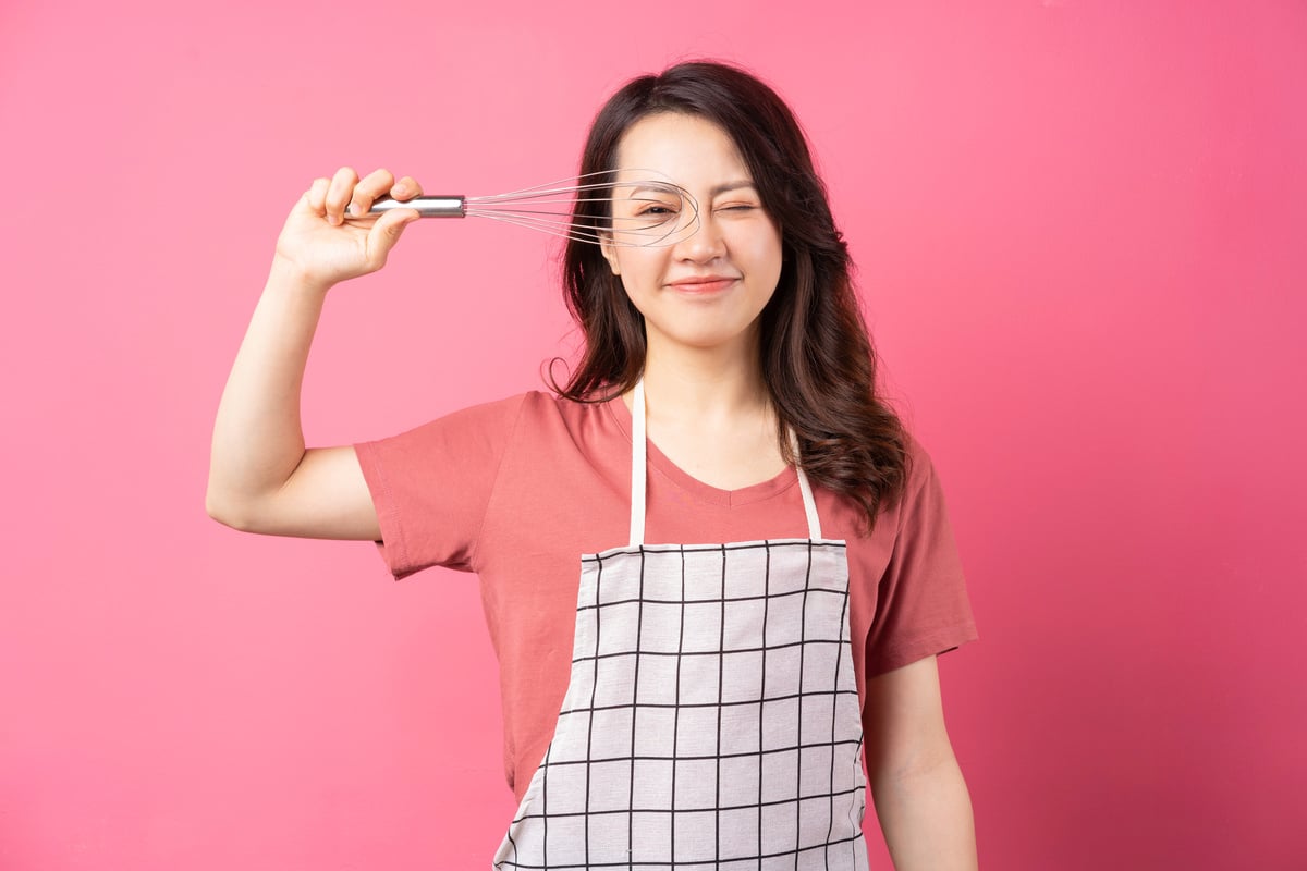 Housewife Holding Whisk Cheerful Expressive over Pink Background